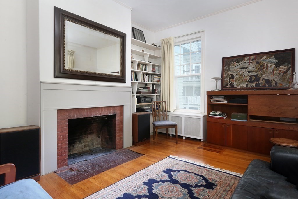 53 Brington Road Brookline, MA 02445 - Photo 3 of 12 a living room with furniture a flat screen tv and a fireplace