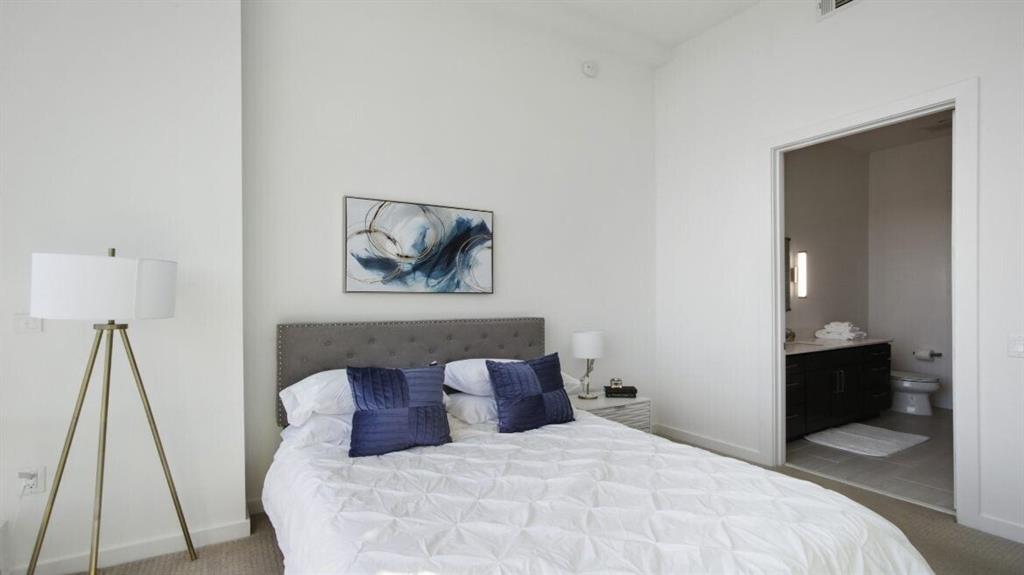 205 12th Street Northeast, Unit 2005 Atlanta, GA 30309 - Photo 20 of 25 a bedroom with a bed and a flat tv screen