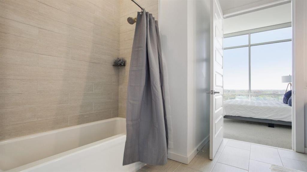 205 12th Street Northeast, Unit 2005 Atlanta, GA 30309 - Photo 21 of 25 a bathroom with a tub and a shower