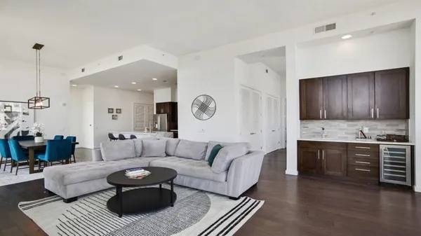a living room with furniture and a wooden floor