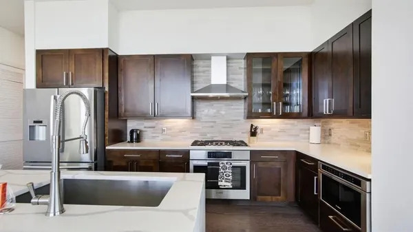 a kitchen with stainless steel appliances granite countertop a stove a refrigerator and a sink