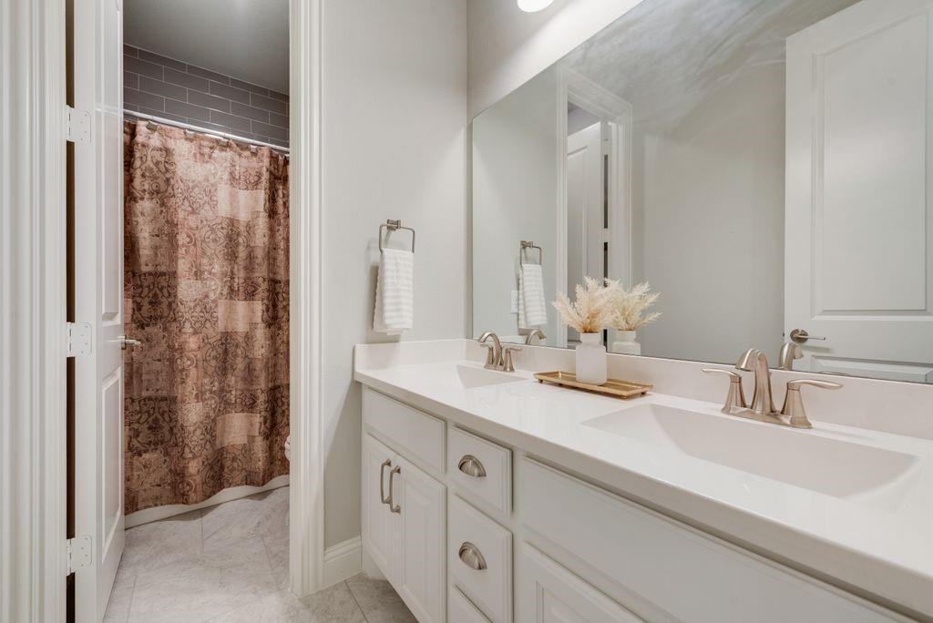 2425 Eclipse Place Celina, TX 75009 - Photo 27 of 40 a bathroom with a double vanity sink mirror and shower