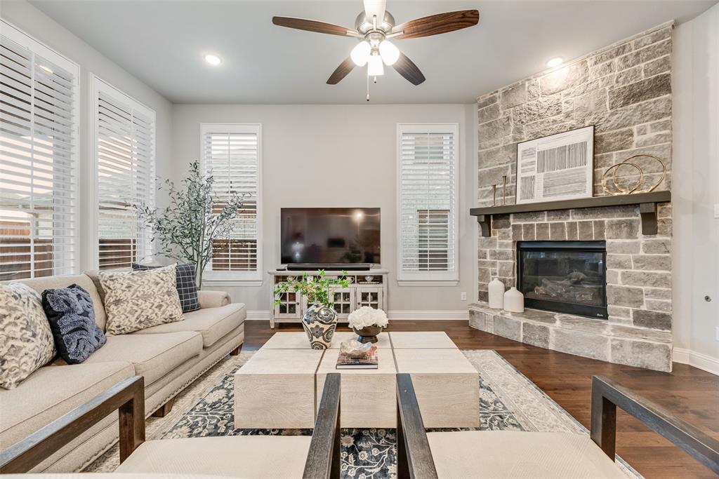 2425 Eclipse Place Celina, TX 75009 - Photo 6 of 40 a living room with furniture a flat screen tv and a fireplace