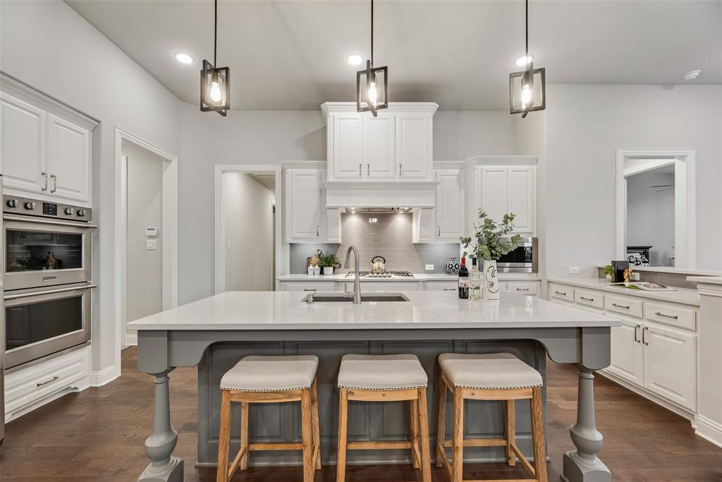 2425 Eclipse Place Celina, TX 75009 - Photo 8 of 40 a kitchen with stainless steel appliances kitchen island granite countertop a table and chairs in it