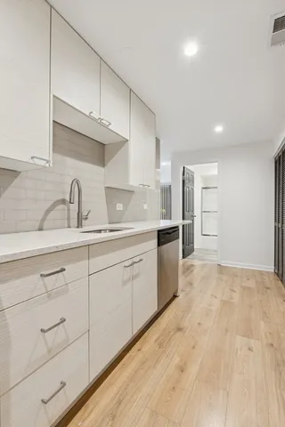 a kitchen with granite countertop a sink stainless steel appliances and cabinets