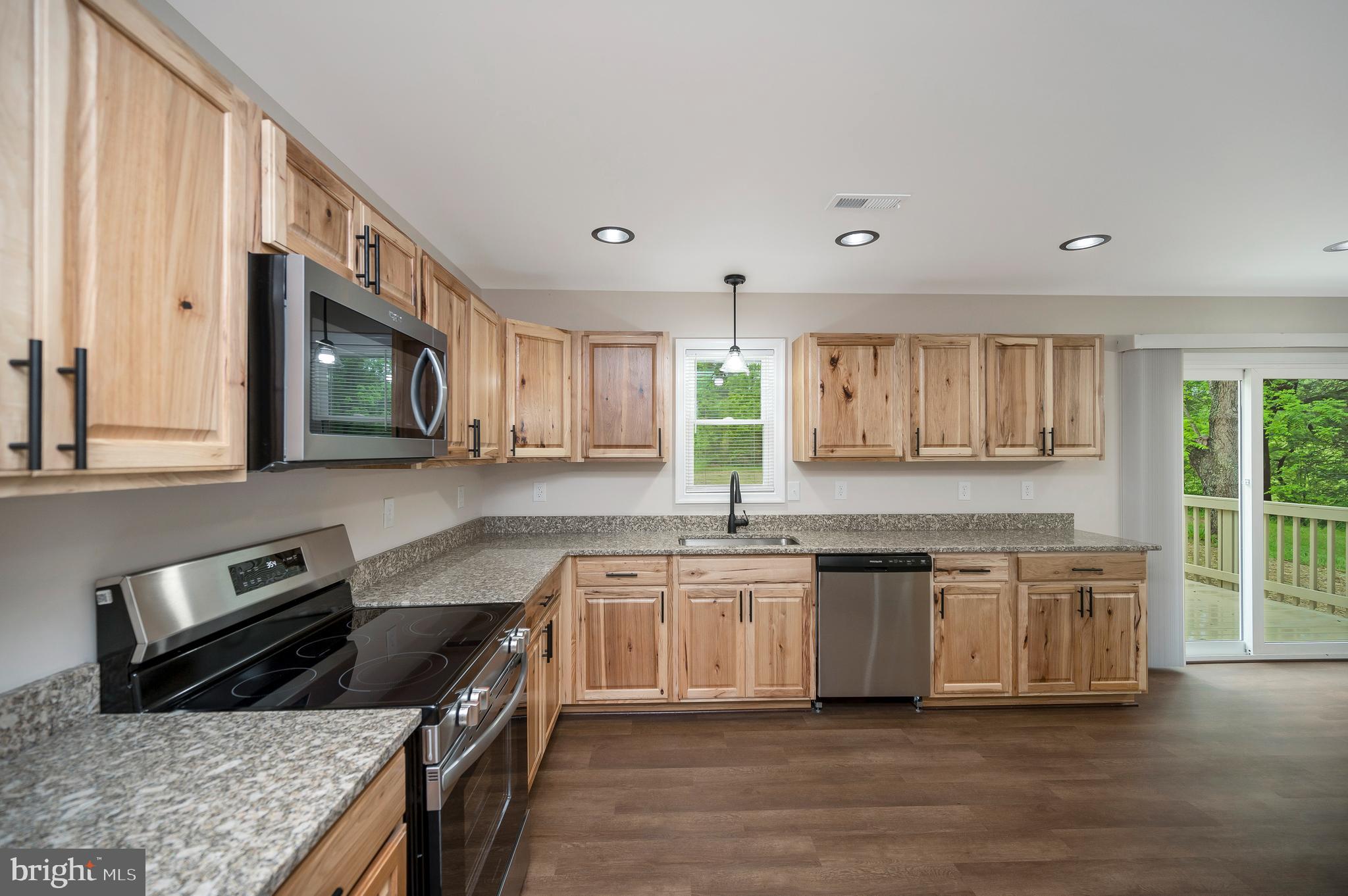 14169 Silver Hill Road Sumerduck, VA 22742 - Photo 8 of 40 a kitchen with stainless steel appliances granite countertop a stove a sink and a microwave
