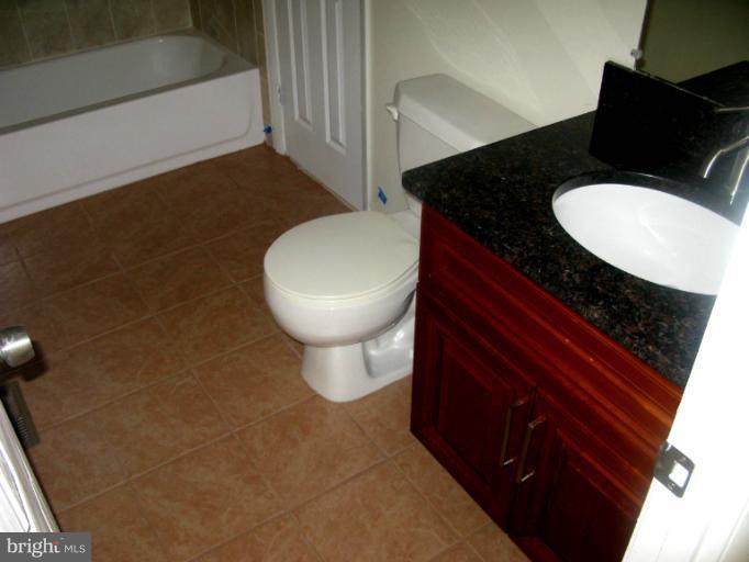 5618 Westgate Road Lanham, MD 20706 - Photo 2 of 17 a bathroom with a granite countertop sink and a mirror