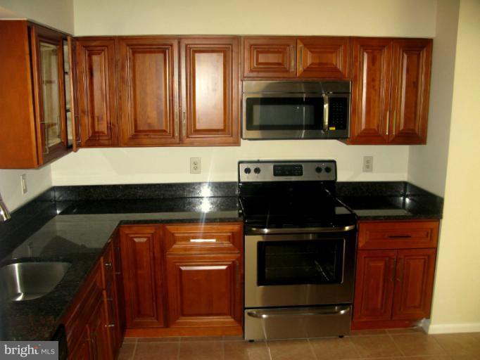 5618 Westgate Road Lanham, MD 20706 - Photo 12 of 17 a kitchen with granite countertop a stove and a microwave