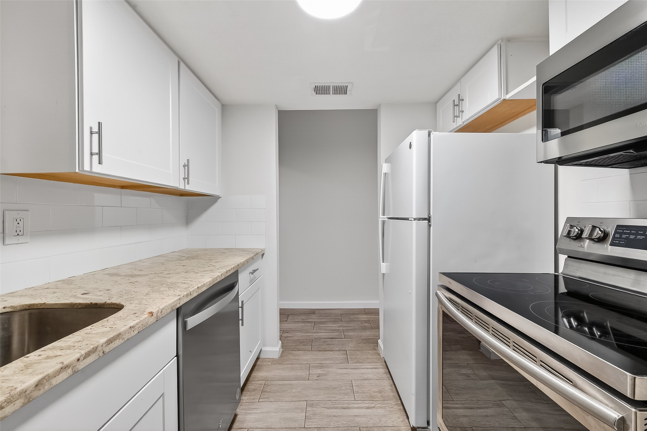811 Threadneedle Street, Unit 258 Houston, TX 77079 - Photo 18 of 39 a kitchen with stainless steel appliances granite countertop a refrigerator and a sink
