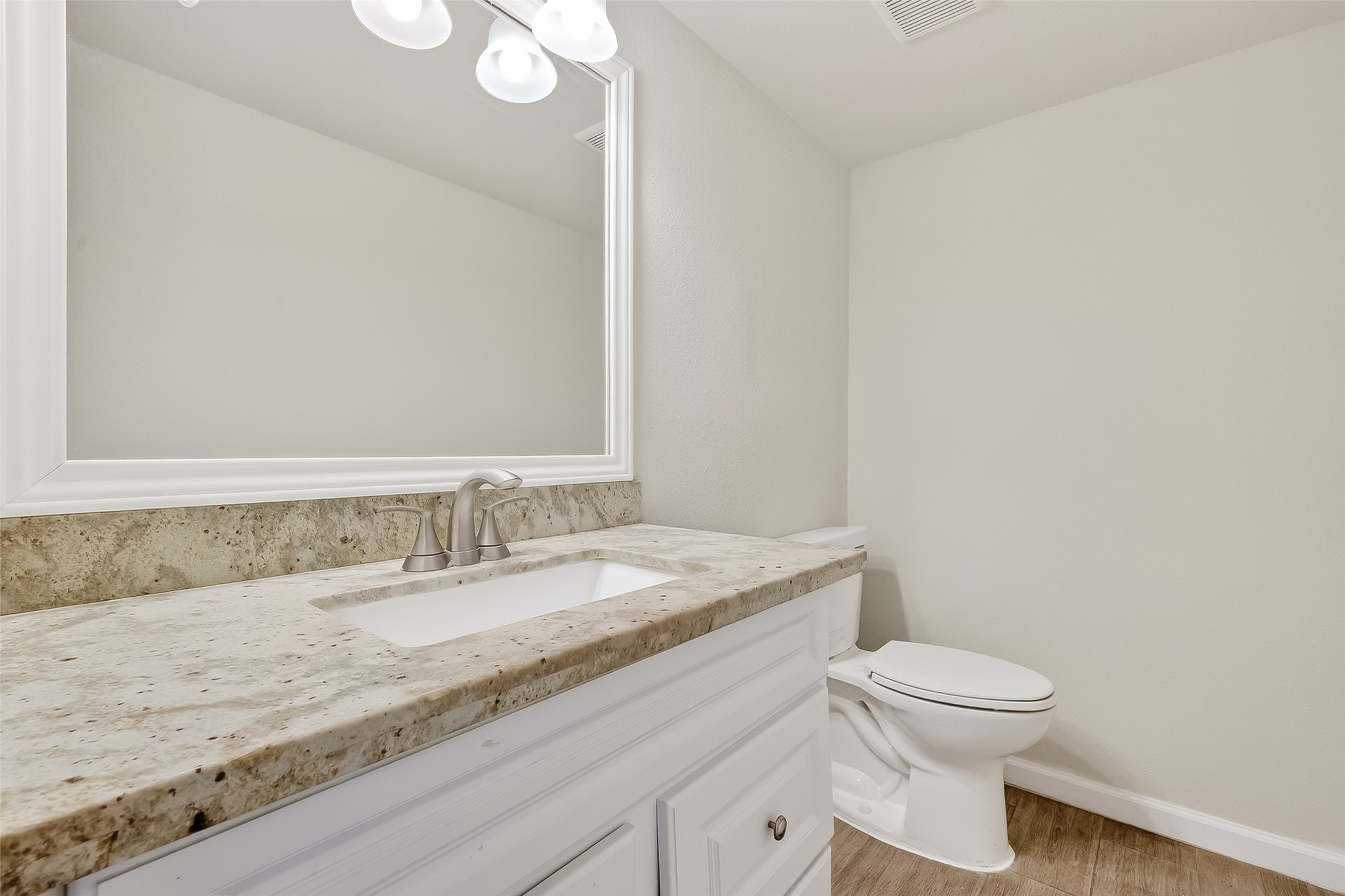 811 Threadneedle Street, Unit 258 Houston, TX 77079 - Photo 21 of 39 a bathroom with a granite countertop sink a toilet and a mirror