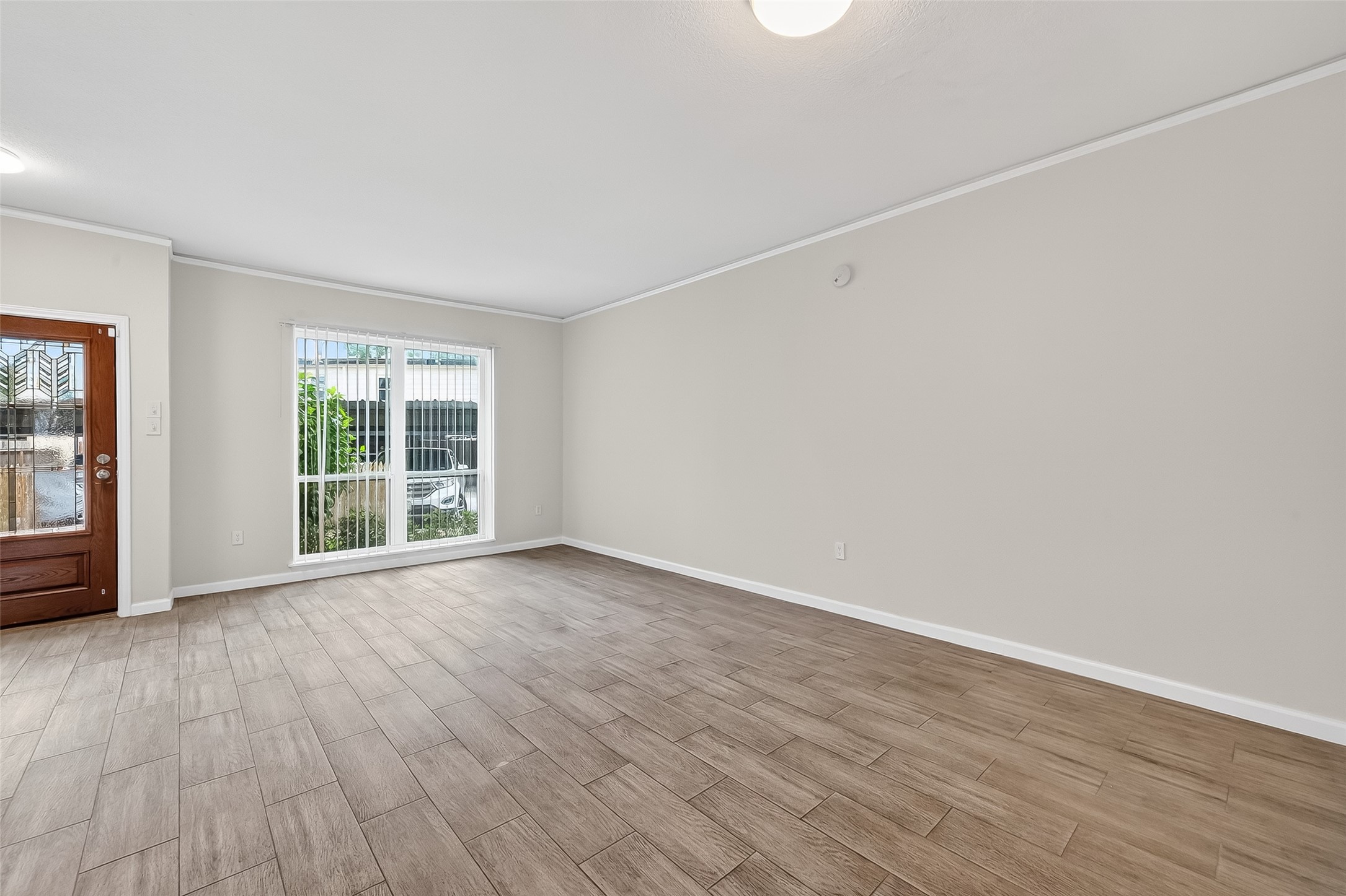 811 Threadneedle Street, Unit 258 Houston, TX 77079 - Photo 9 of 39 a view of an empty room with wooden floor and a window