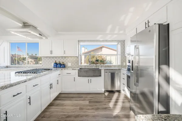 a kitchen with granite countertop a refrigerator and a sink