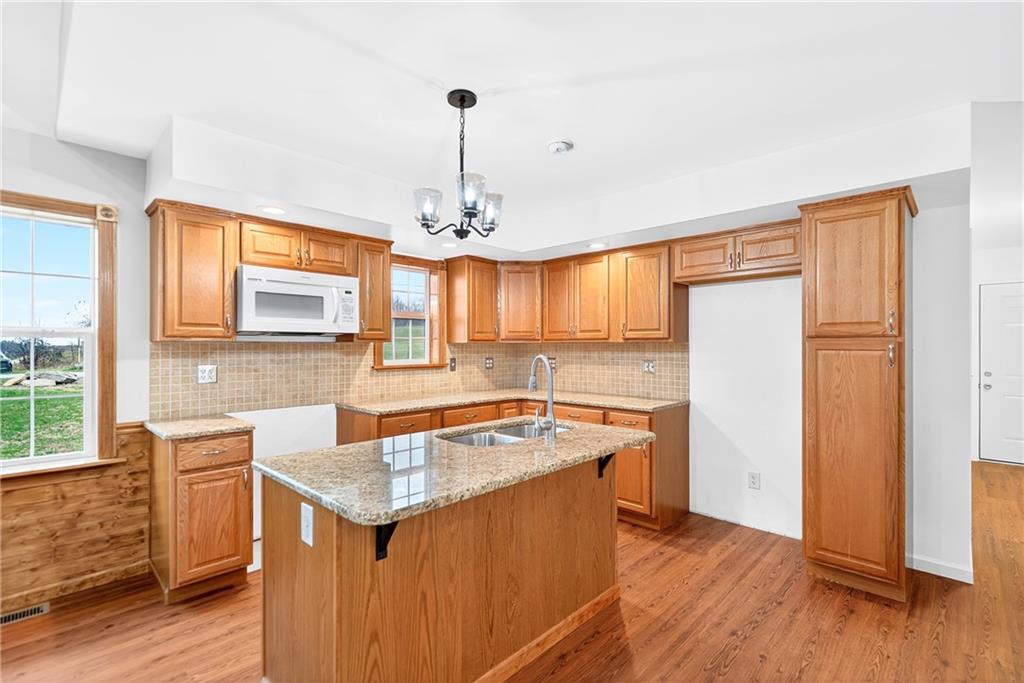 524 Sawmill Road Dawson, PA 15428 - Photo 22 of 50 a kitchen that has a sink a stove and a wooden floor