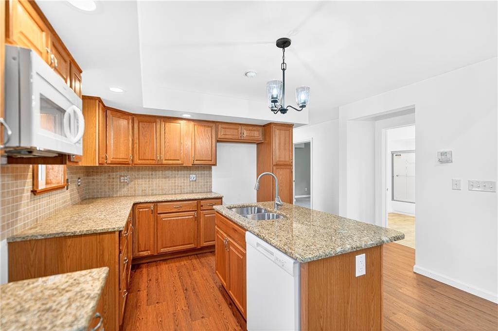 524 Sawmill Road Dawson, PA 15428 - Photo 24 of 50 a kitchen with granite countertop kitchen island stainless steel appliances a sink stove and wooden floor