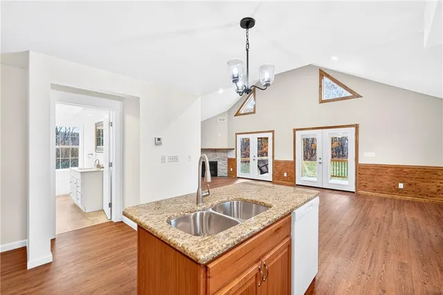 a kitchen that has a sink a window and wooden floor