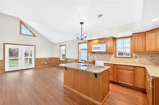 a kitchen with stainless steel appliances granite countertop a sink stove and wooden floor