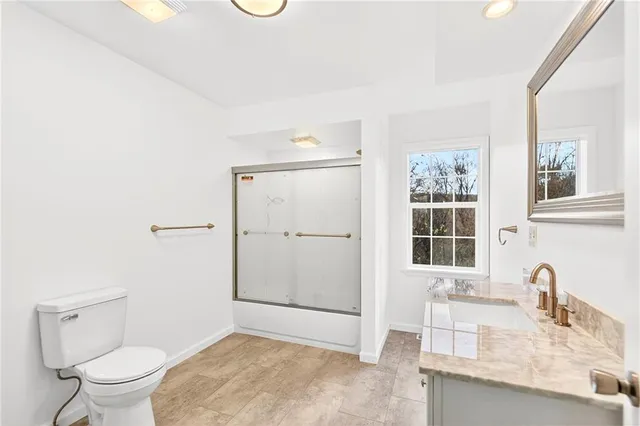 a bathroom with a granite countertop sink toilet and shower
