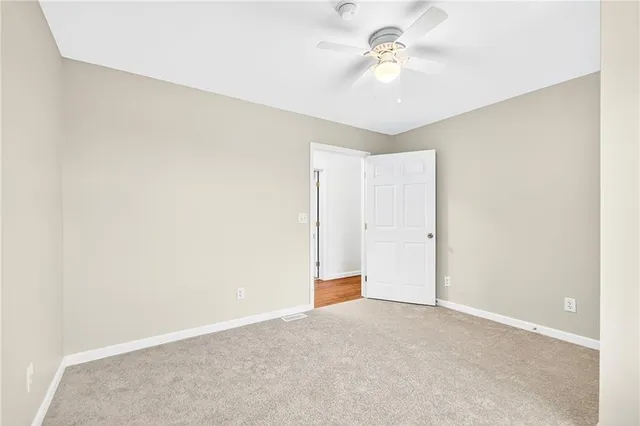 a view of a room with a ceiling fan and a window