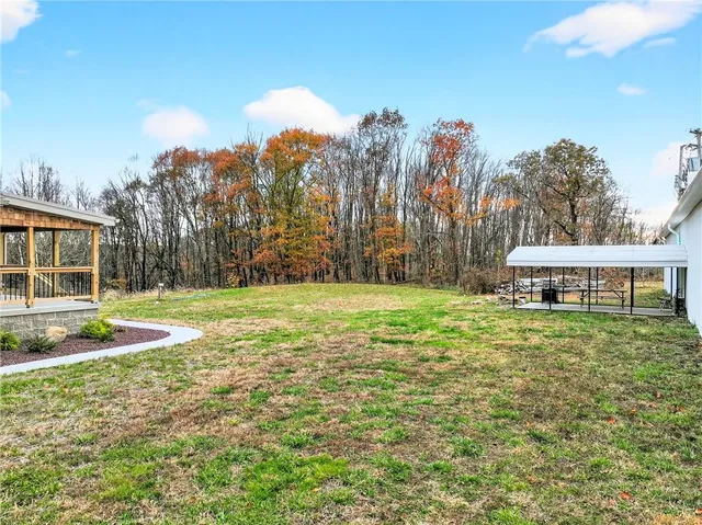 a view of a house with backyard and trees