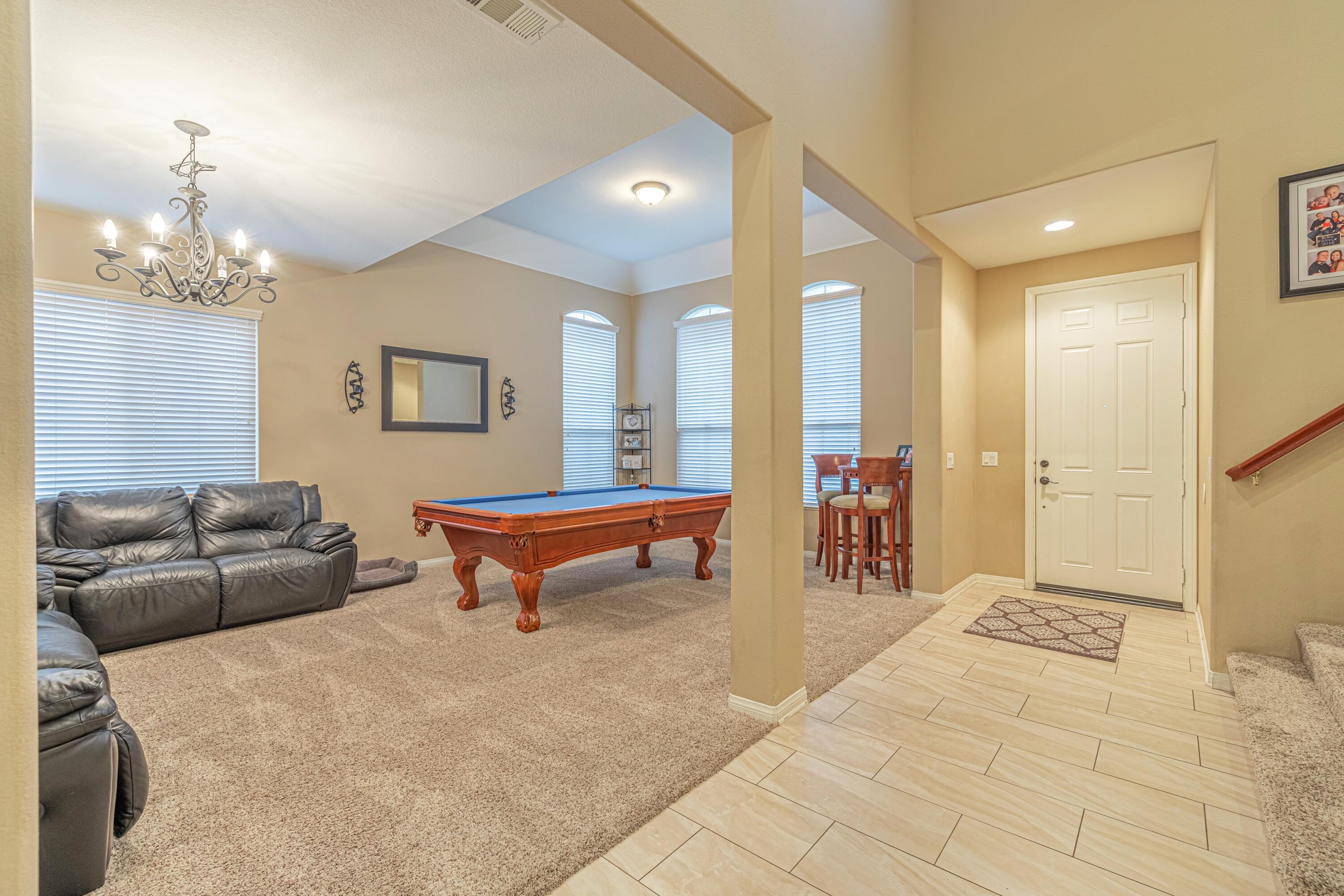 4403 Edam Street Lancaster, CA 93536 - Photo 13 of 42 a living room with furniture a table and a chandelier
