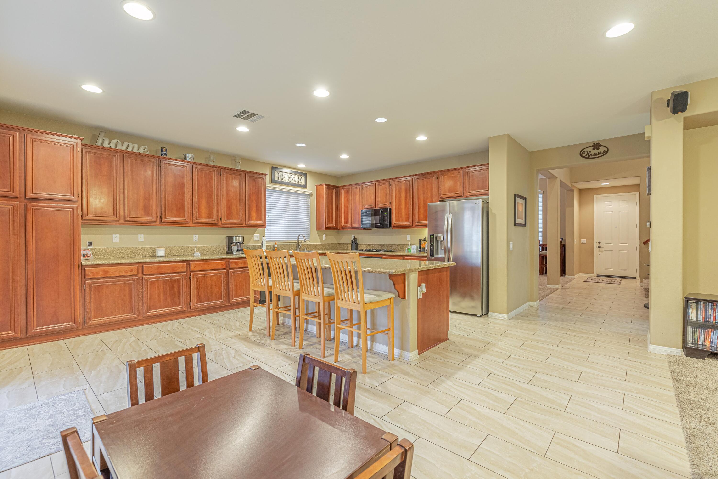4403 Edam Street Lancaster, CA 93536 - Photo 3 of 42 a kitchen with stainless steel appliances granite countertop a stove top oven a sink a refrigerator and cabinets