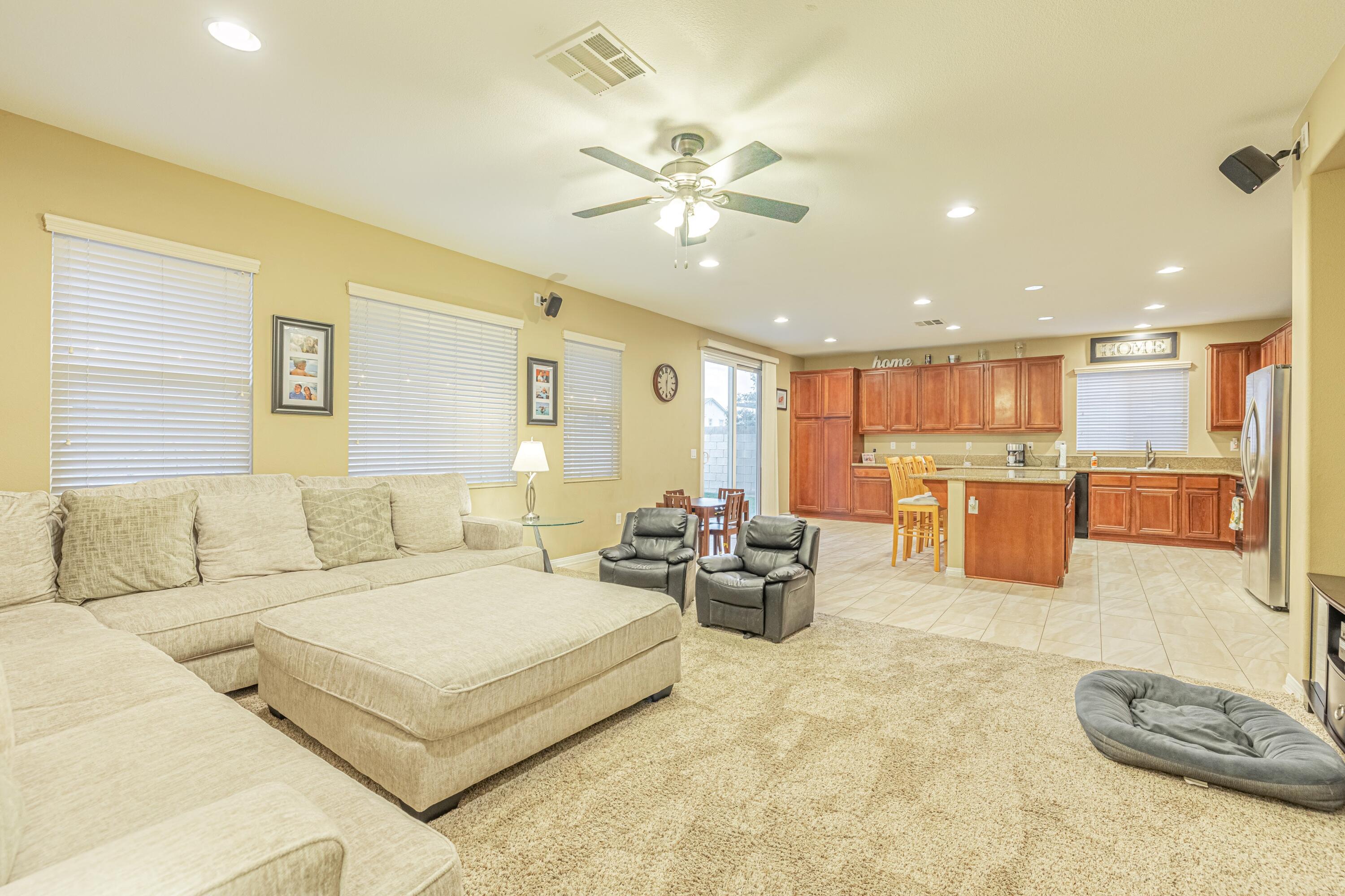 4403 Edam Street Lancaster, CA 93536 - Photo 21 of 42 a living room with furniture kitchen view and a chandelier