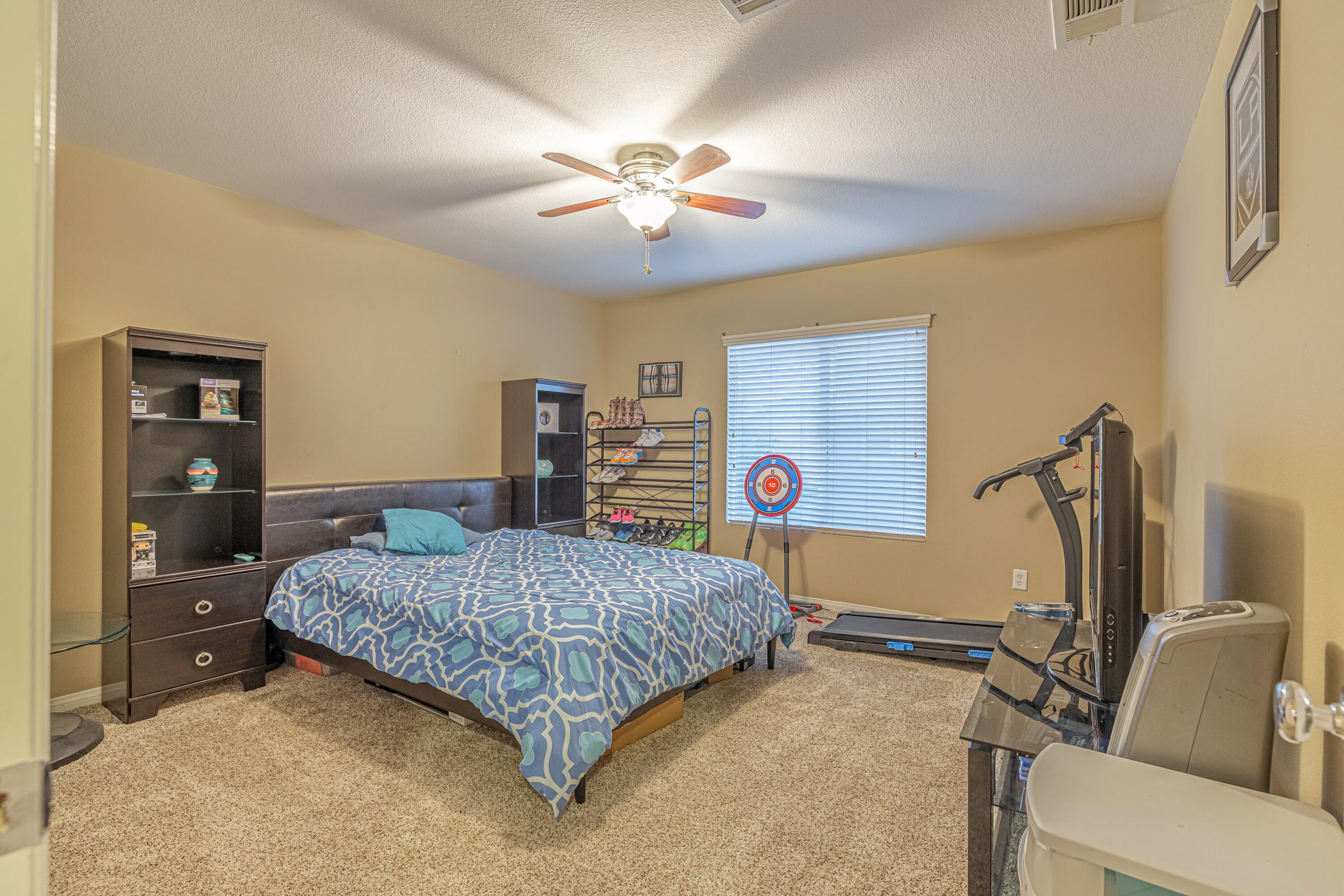 4403 Edam Street Lancaster, CA 93536 - Photo 30 of 42 a bedroom with a bed and a chandelier
