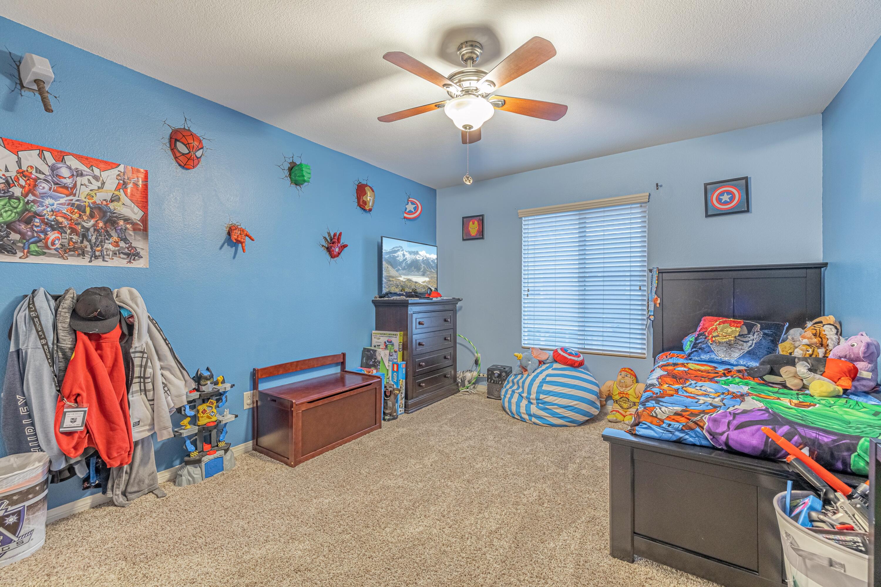 4403 Edam Street Lancaster, CA 93536 - Photo 33 of 42 a bedroom with a bed and a chandelier
