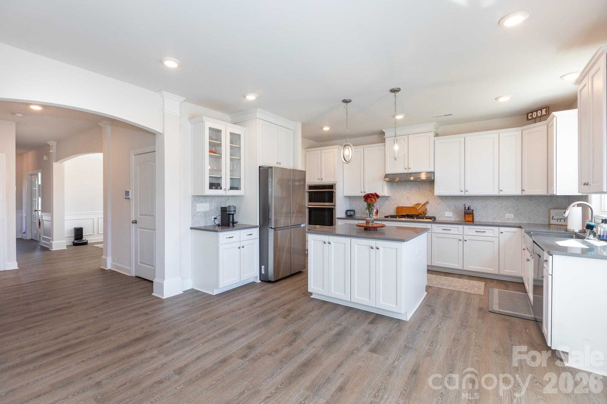 5415 Haystack Avenue Indian Land, SC 29707 - Photo 2 of 44 a kitchen with stainless steel appliances granite countertop a refrigerator a stove top oven a sink and white cabinets with wooden floor