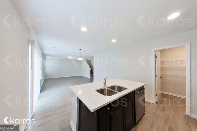 a kitchen with a sink a refrigerator and cabinets