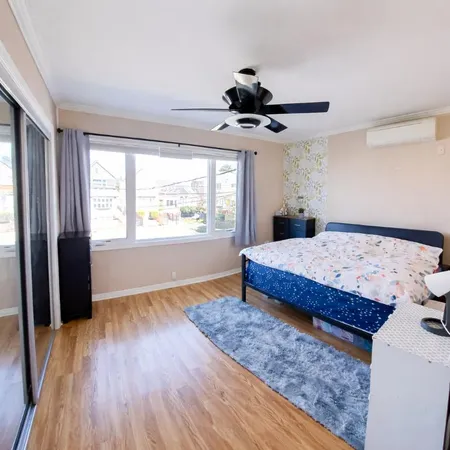 a bedroom with a large bed a chandelier and windows
