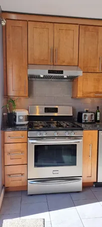 a kitchen with stainless steel appliances granite countertop a stove a sink and a microwave