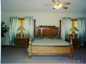 14 Remington Road Ormond Beach, FL 32174 - Photo 6 of 8 a bedroom with a bed and a chandelier