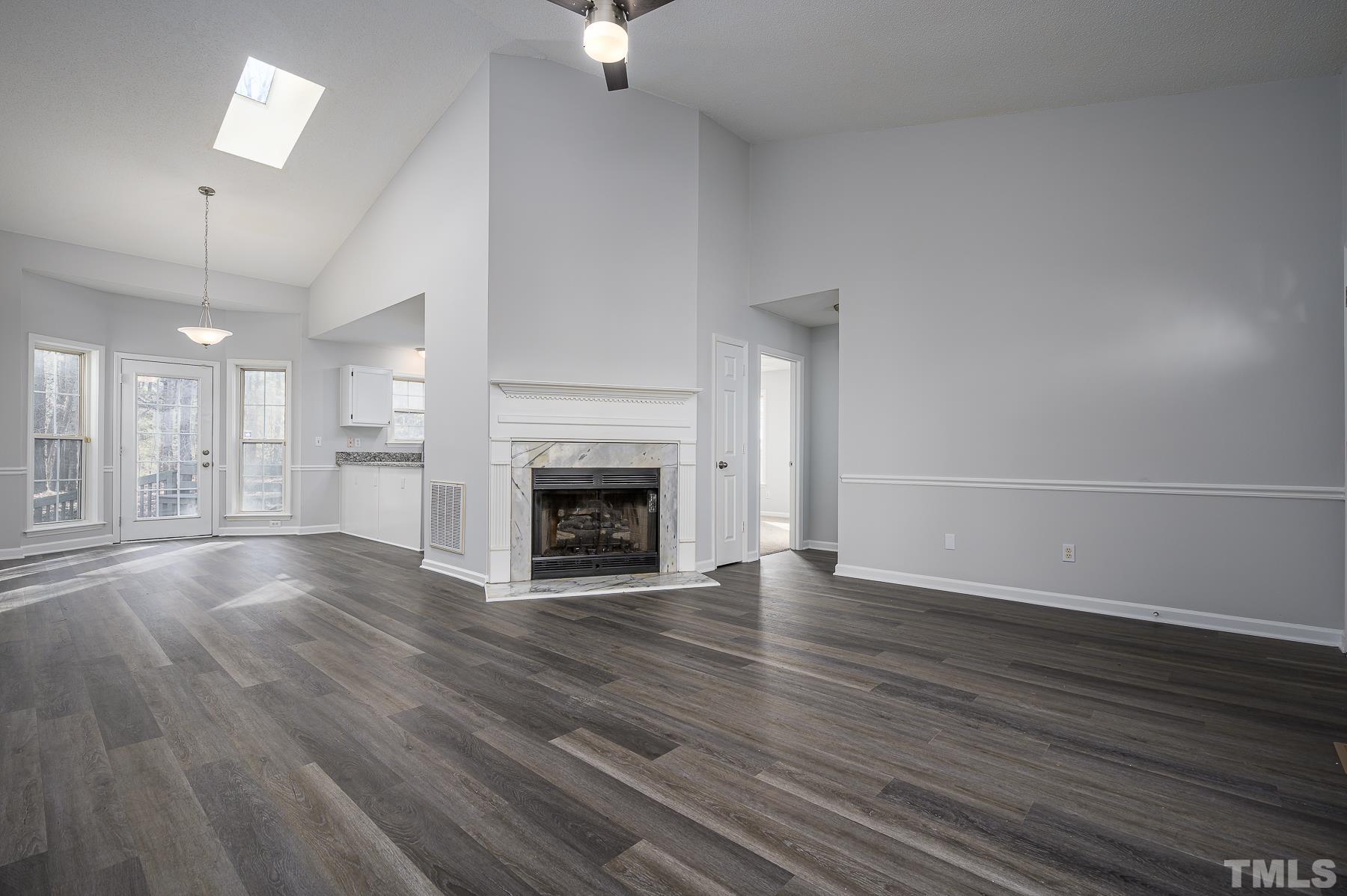 1500 Edgemont Road Wendell, NC 27591 - Photo 4 of 20 an empty room with wooden floor fireplace and windows