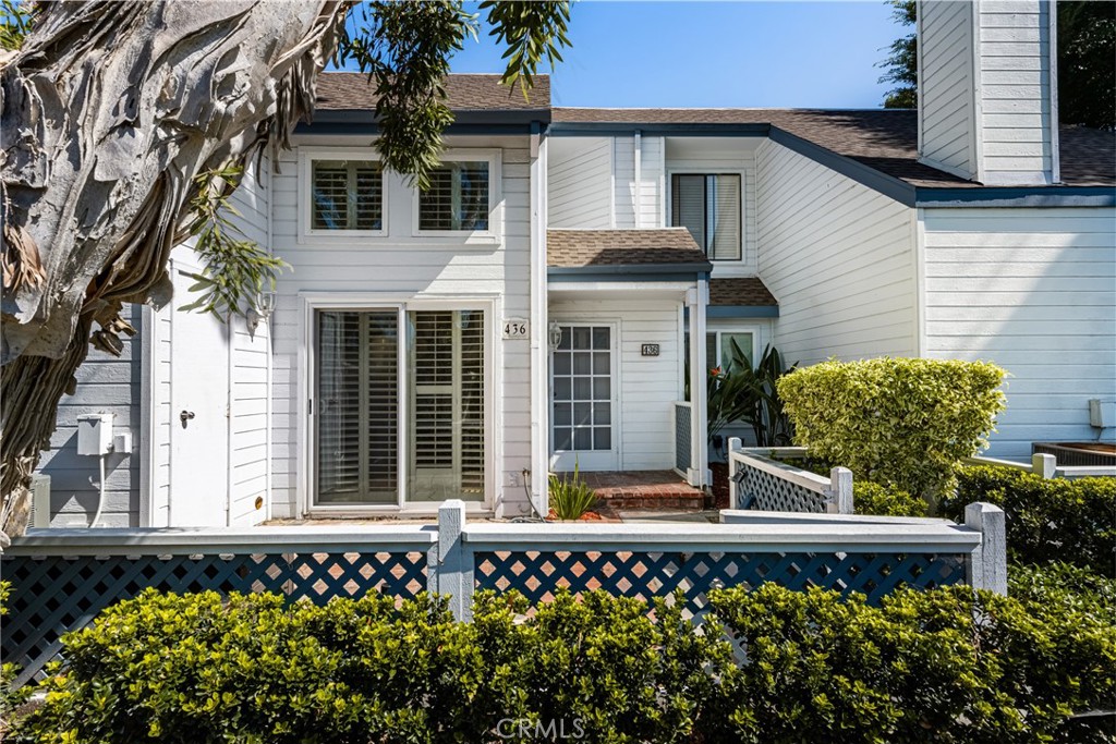 a view of a house with a small yard and potted plants