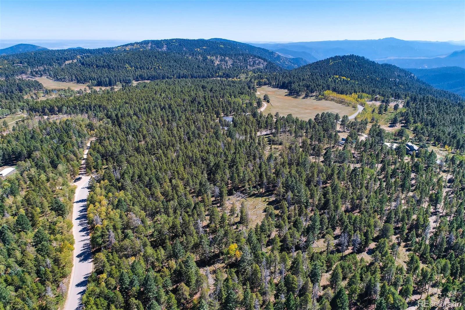 12171 South Ridge Road Conifer, CO 80433 - Photo 7 of 11 a view of a lush green hillside and houses