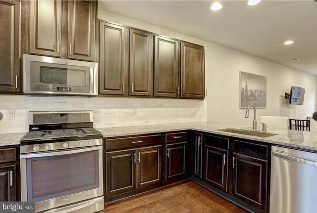a kitchen with microwave a refrigerator and chairs