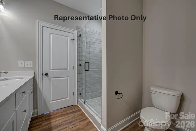 a bathroom with a granite countertop toilet and a shower