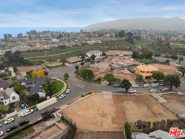 an aerial view of a house with a garden and lake view
