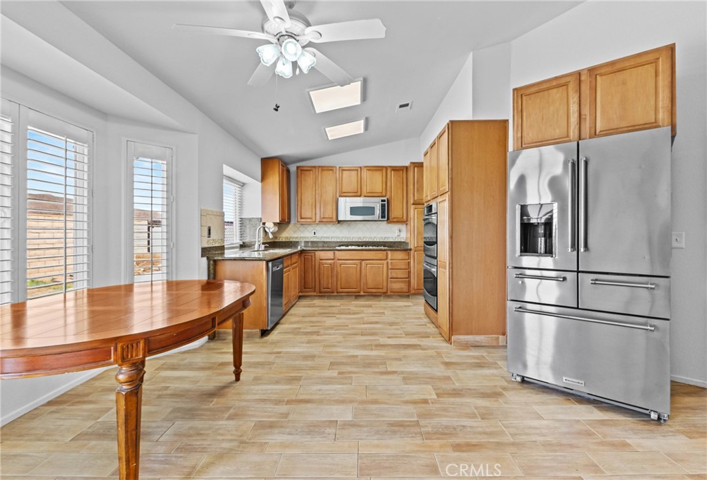 27126 Rio Vista Drive Menifee, CA 92586 - Photo 17 of 47 a kitchen with stainless steel appliances granite countertop a refrigerator a stove a sink dishwasher and a refrigerator with wooden floor
