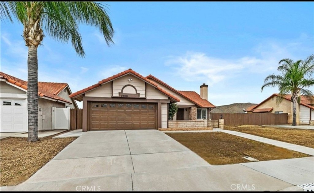 27126 Rio Vista Drive Menifee, CA 92586 - Photo 2 of 47 a front view of a house with a yard and palm trees