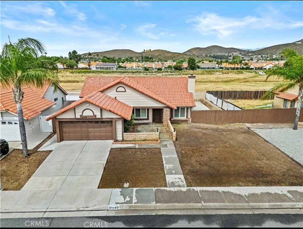 27126 Rio Vista Drive Menifee, CA 92586 - Photo 3 of 47 a view of a white house next to a lake with houses in the back