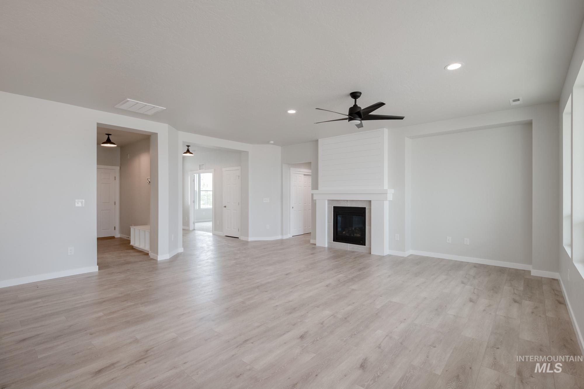 5261 South Memory Avenue Meridian, ID 83642 - Photo 12 of 30 Unfurnished living room with a ceiling fan, recessed lighting, a fireplace, and light wood finished floors