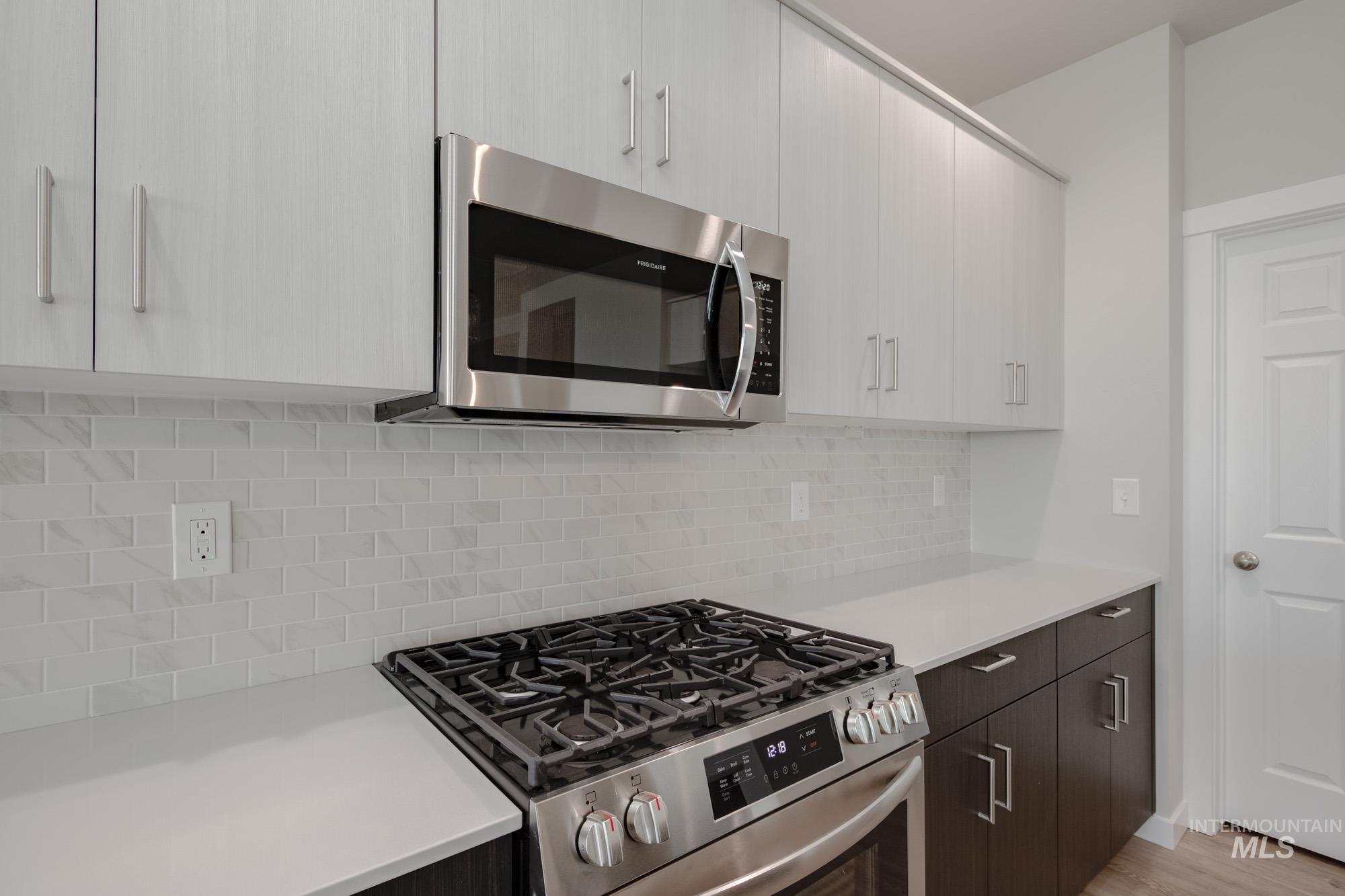 5261 South Memory Avenue Meridian, ID 83642 - Photo 5 of 30 Dual tone kitchen with stainless steel appliances, modern cabinets, two tone color scheme, and tasteful backsplash