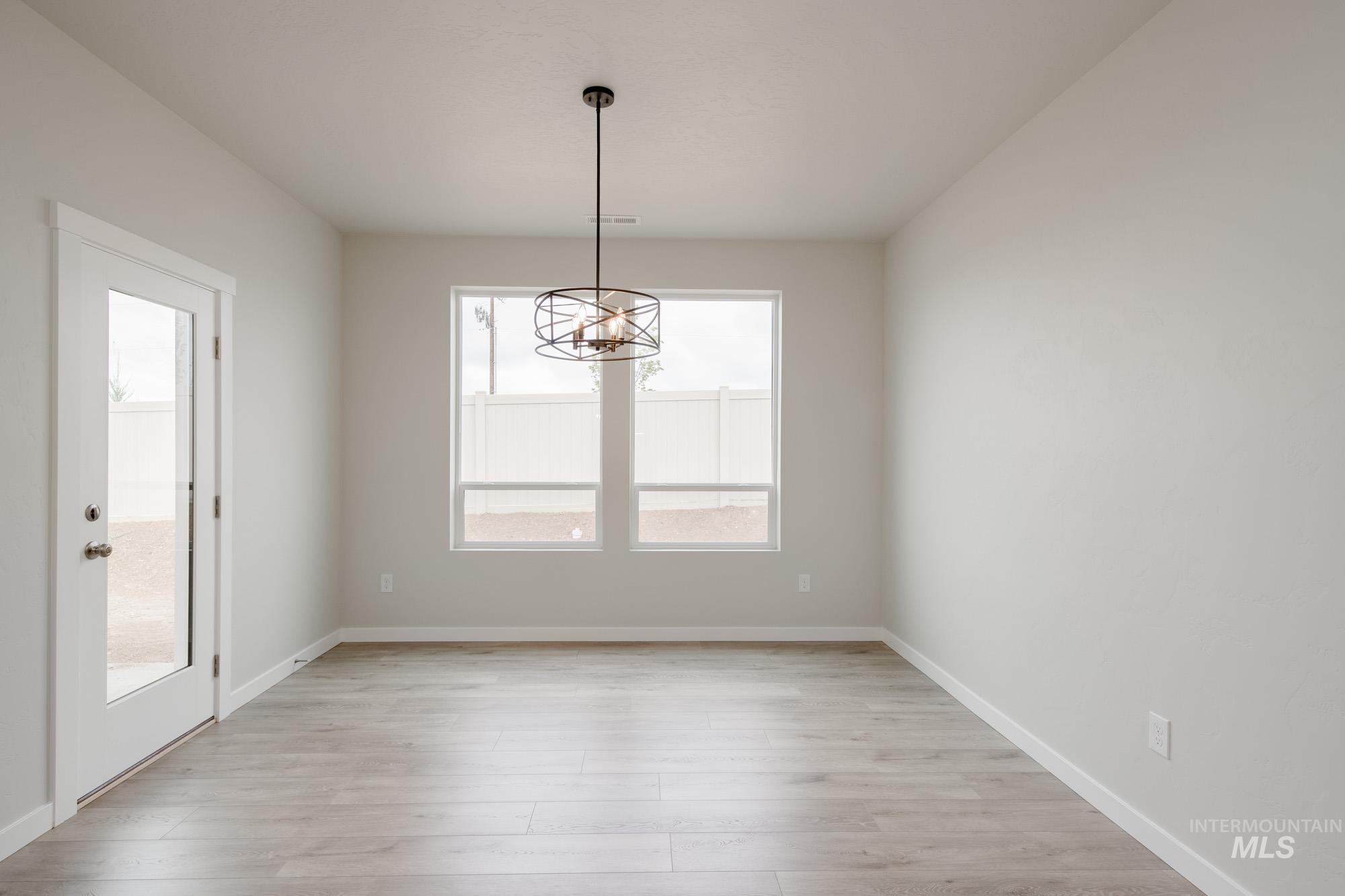 5261 South Memory Avenue Meridian, ID 83642 - Photo 7 of 30 Unfurnished dining area with light wood finished floors and suspended lighting