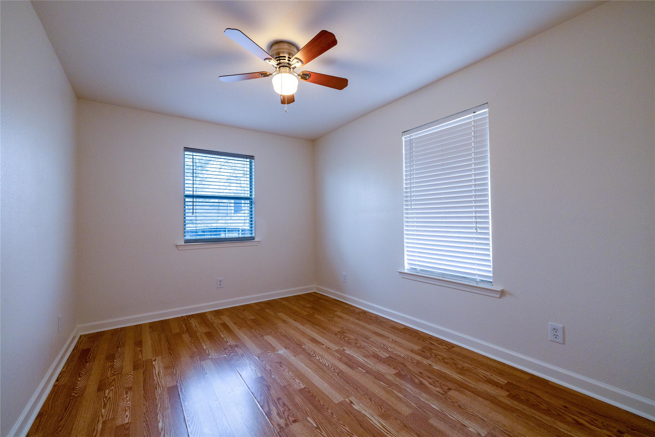 4304 Scottsdale Road Austin, TX 78721 - Photo 7 of 21 Bright interior space featuring wood-finish flooring, white walls, and a ceiling fan with integrated lighting