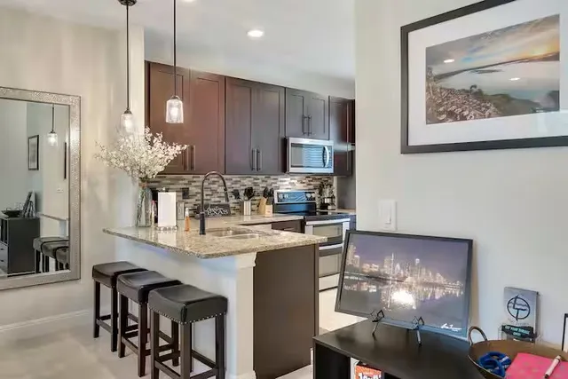 a kitchen with stainless steel appliances granite countertop a refrigerator and a stove top oven