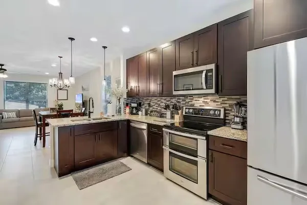 a kitchen with kitchen island granite countertop wooden cabinets stainless steel appliances and a center island