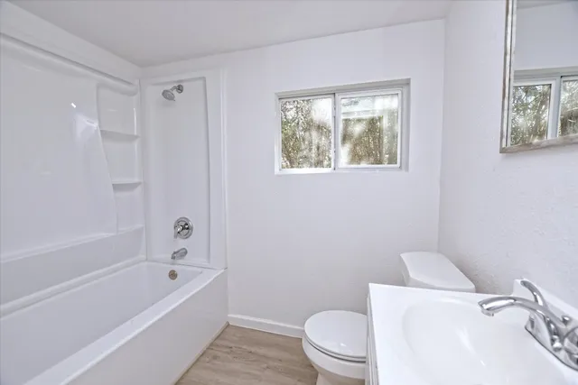 a white toilet sitting next to a bath tub