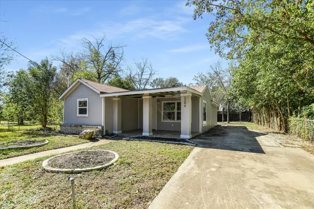 a front view of a house with a yard and trees